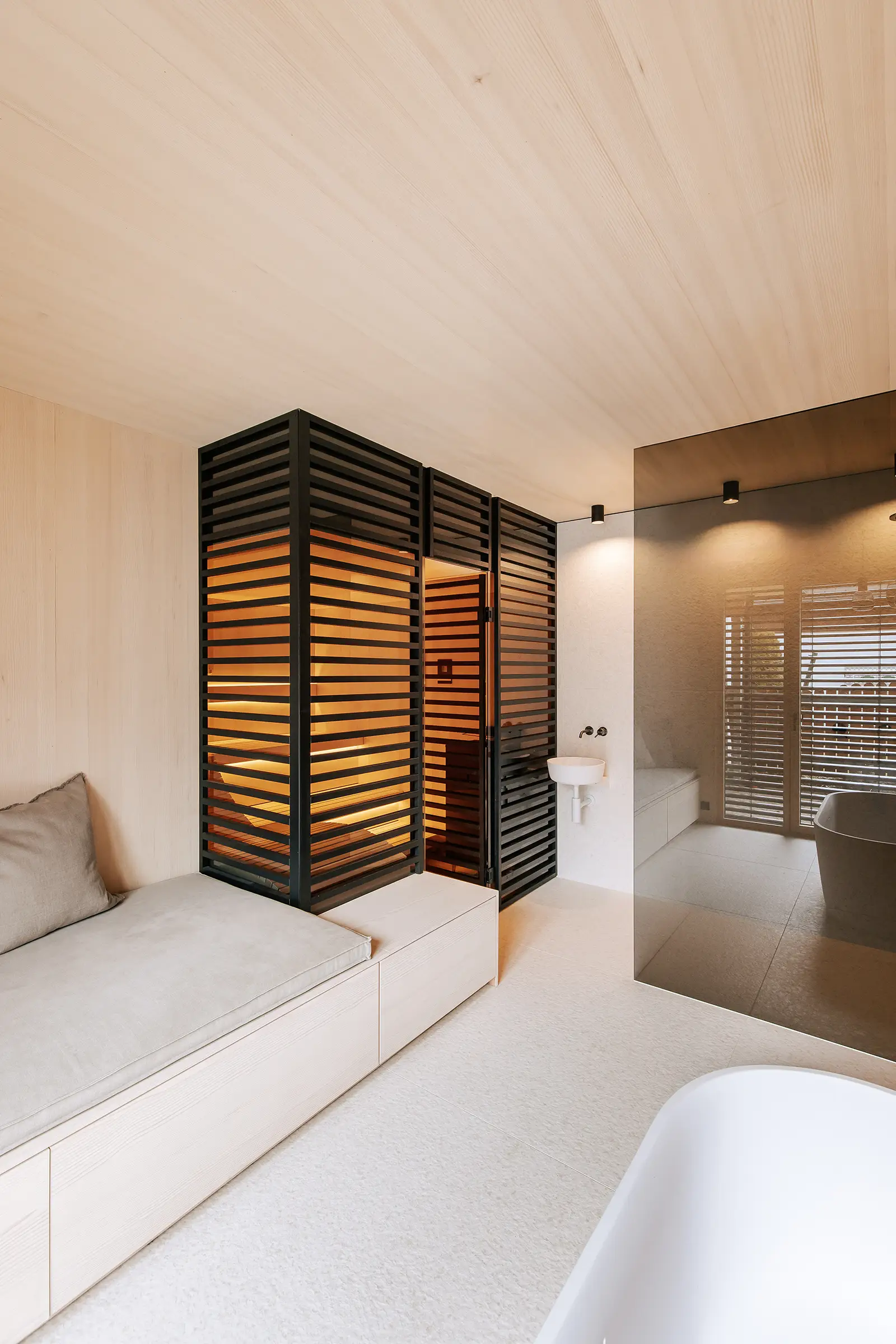 Moderne Sauna im Japandi Stil mit schwarzem Sichtschutz und Daybed im Badezimmer