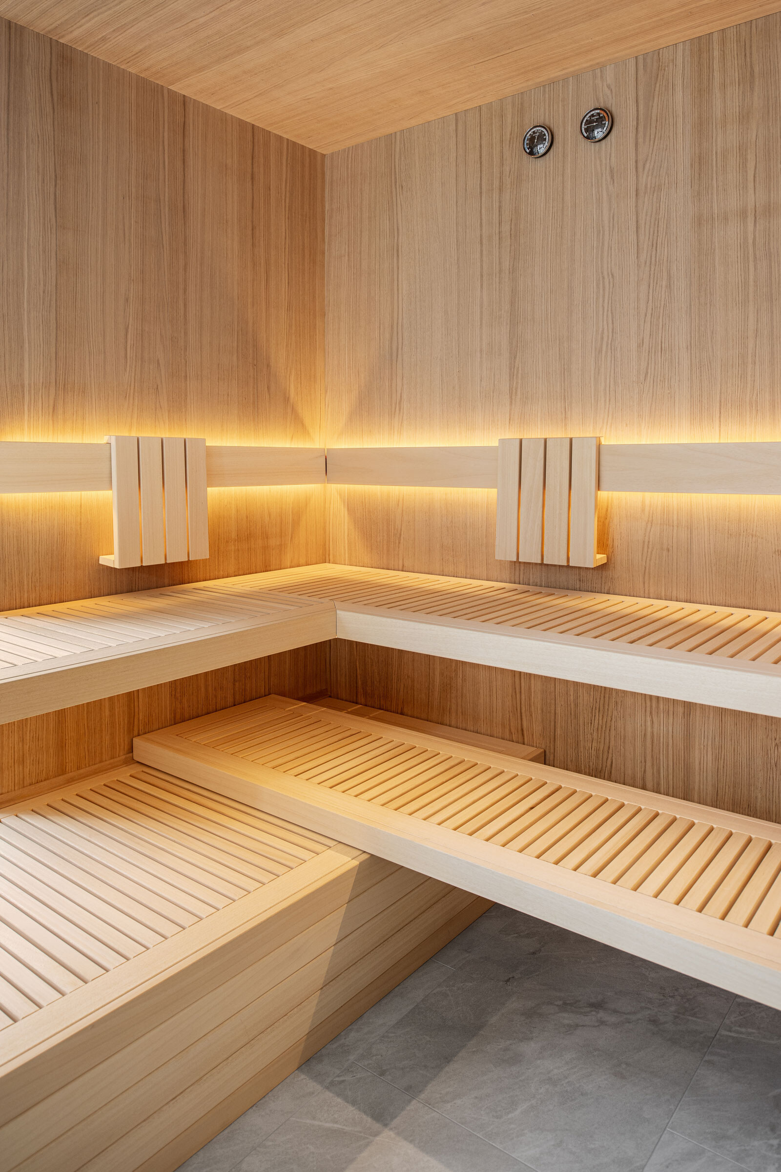 Modernes Sauna-Interior in minimalistischem Scandi-Stil aus hellem Eichenholz mit dezenter Beleuchtung