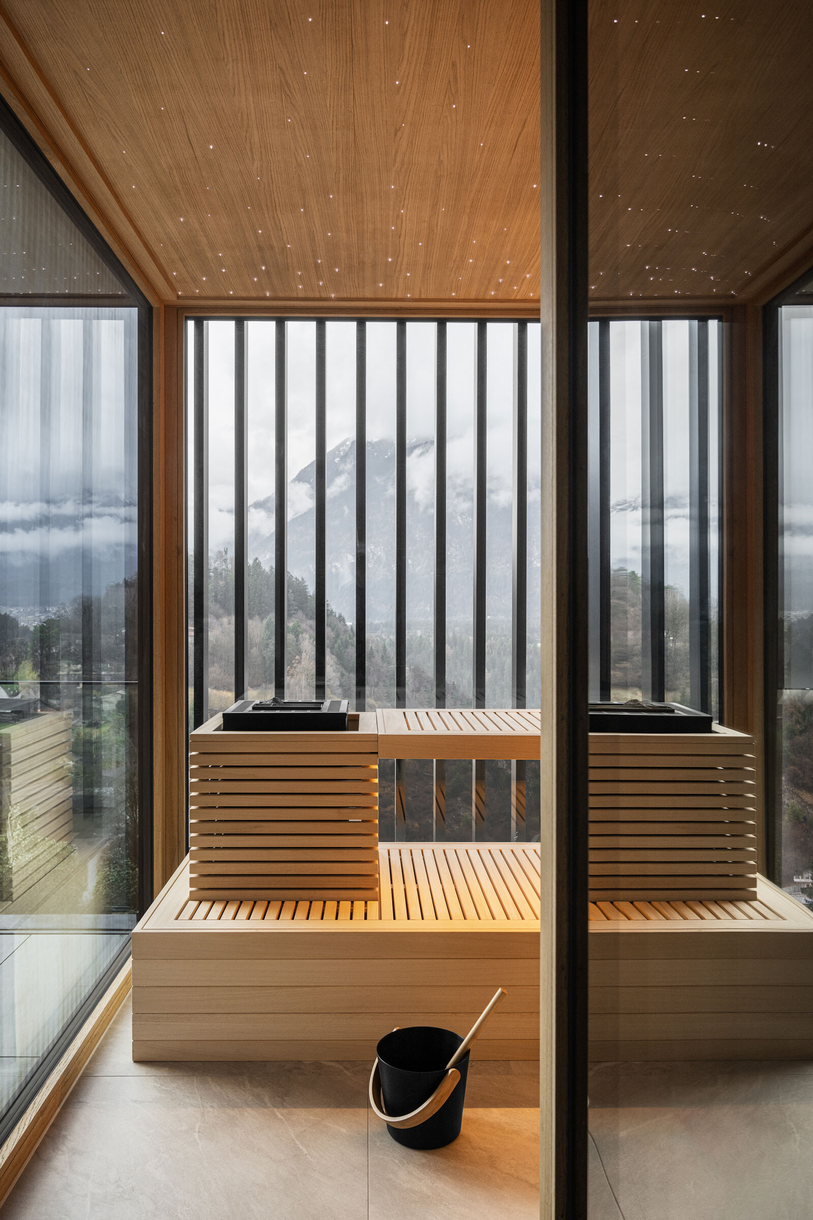 Maßgeschneiderte Sauna am Balkon in puristischem Design mit Panoramafenster, Lamellen-Sichtschutz und integriertem Ofen